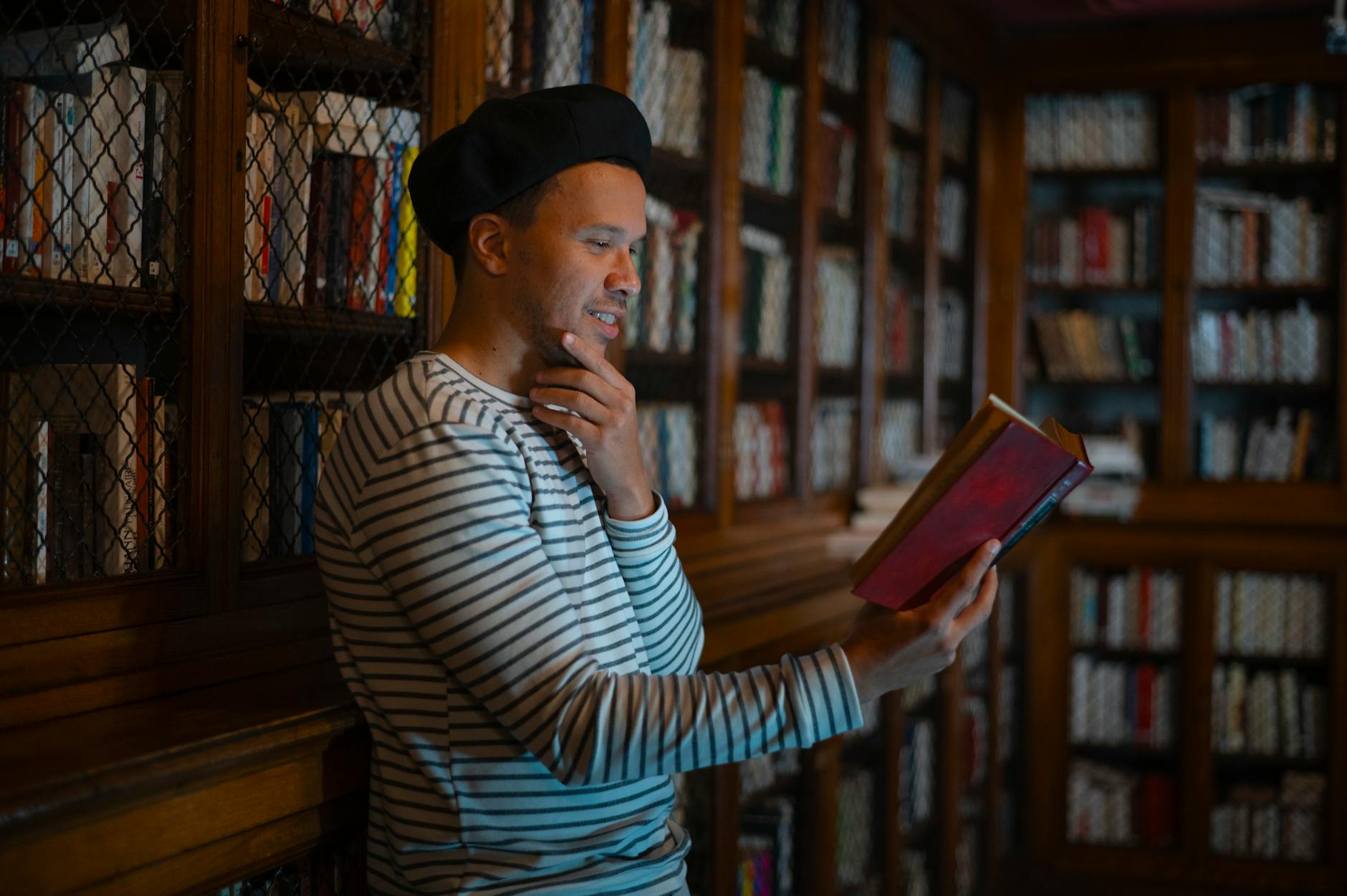 Escritor investigando en una biblioteca con libros abiertos y un cuaderno
