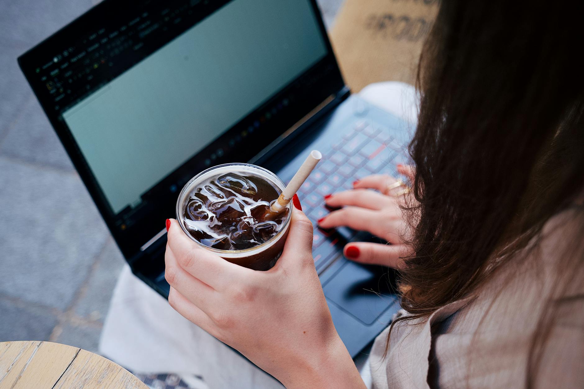 Escritor tecleando el primer capítulo de su novela en un portátil en una cafetería